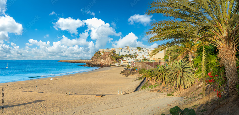 Stroll along Morro Jable's palm-lined promenade in Fuerteventura, with azure waters and sandy shores offering a tranquil Canary Island escape