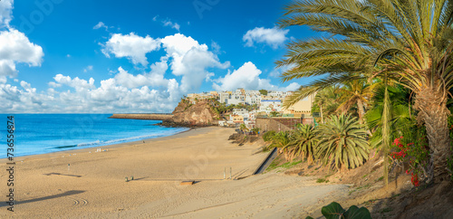 Obraz na płótnie Stroll along Morro Jable's palm-lined promenade in Fuerteventura, with azure waters and sandy shores offering a tranquil Canary Island escape w salonie