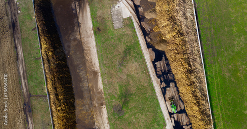 A shot of a manure pit from above with a small loader as a system for working with manure