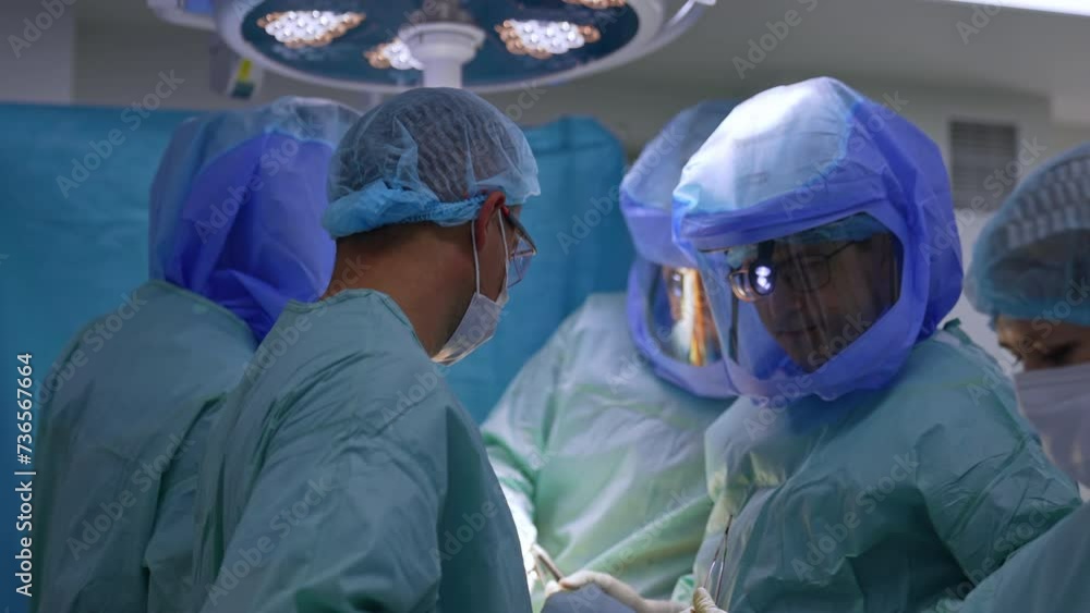 Three surgeons, an assistant and nurse work at orthopedic operation. Cooperation of medics in the surgery room. Three surgeons, an assistant and nurse work at orthopedic operation. Cooperation of medics in the surgery room.