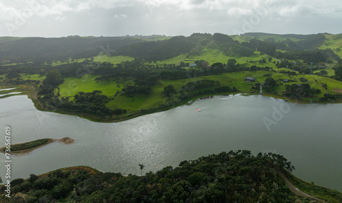 Aerial: Farlmland,lake and forestry on the west coast. Helensville, Auckland, new Zealand.