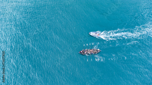 Aerial drone top down photo of sport boat operated by team in emerald calm sea waters with support © Aloshin Evgeniy