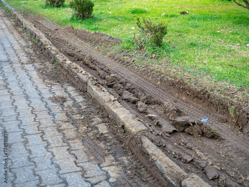Ruts on the lawn. Destroyed lawn. Tire tracks in the mud. Offset track.