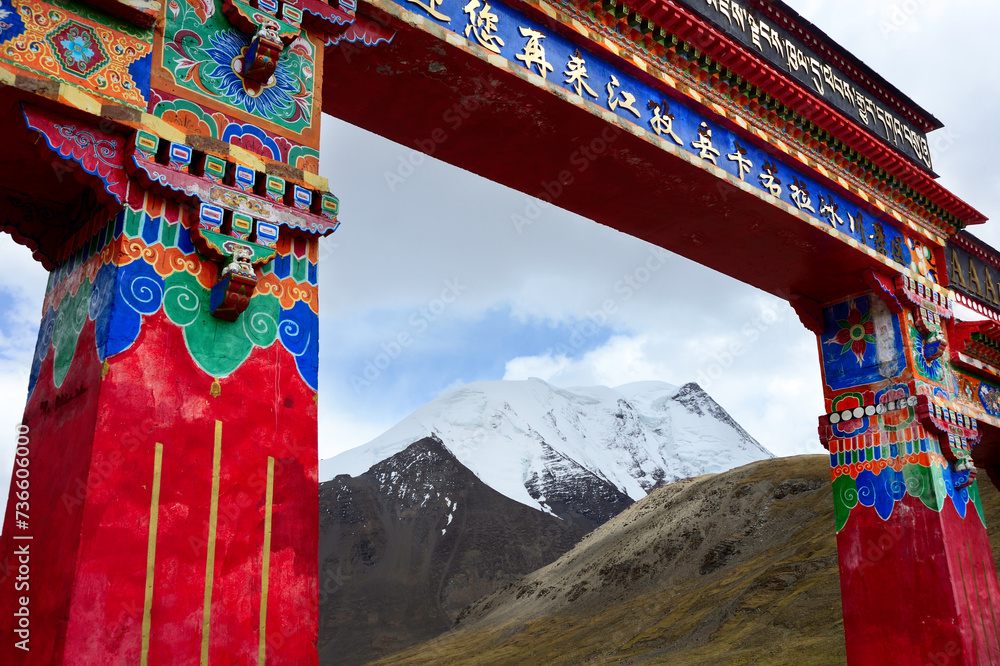 Naklejka premium On Mt. Noijin Kangsang, an overhead structure along Road G349 marks Karo La Pass in The Himalayan mountains.