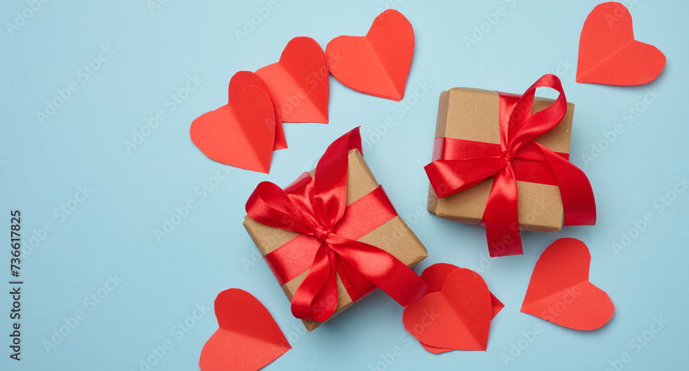 Gift box with red satin ribbon and bow on a blue background.Holiday background with Birthday or Christmas present, flat lay Gift box with red satin ribbon and bow on a blue background.Holiday background with Birthday or Christmas present, flat lay