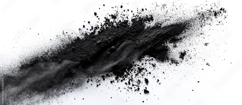 Charcoal powder dispersed alone on white backdrop. Charcoal powder dispersed alone on white backdrop.