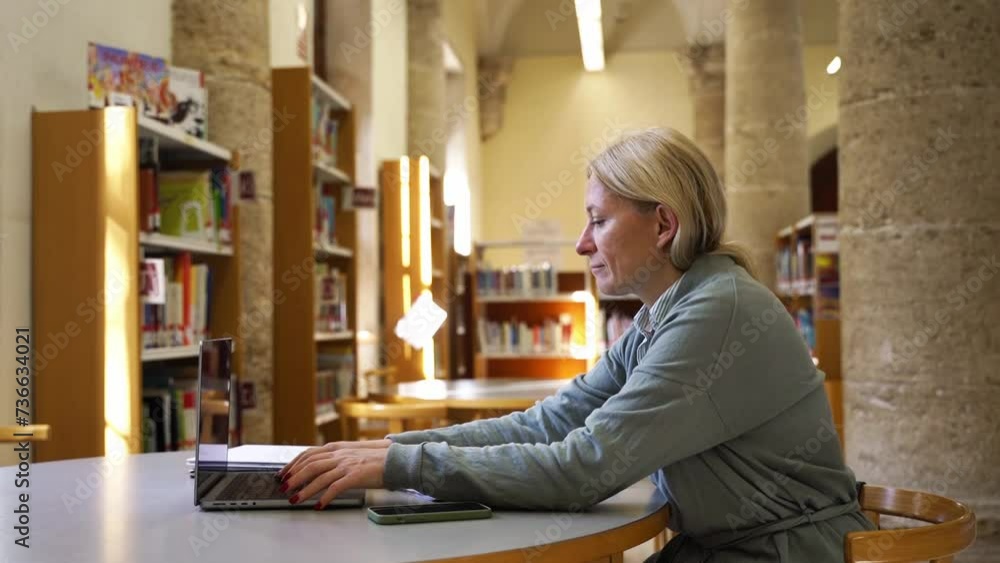 Mature student studying in classroom in school or university. Mid aged woman using laptop for preparation lesson and organize the information materials Write thesis, making notes. Education for adults Mature student studying in classroom in school or university. Mid aged woman using laptop for preparation lesson and organize the information materials Write thesis, making notes. Education for adults