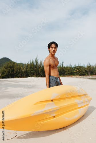 Happy Asian Man Enjoying Kayaking Adventure on a Tropical Beach © SHOTPRIME STUDIO