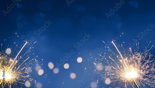 Silvester party New year background banner panorama long- sparklers and bokeh lights on dark blue night sky texture, with space for text