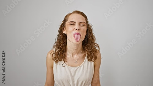 Happy young woman sticking tongue for a fun and funny expression. playful adult displaying joy emotion, standing isolated on white background
