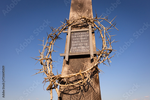Foto Crown of thorns surrounding plaque of John 1:29 Bible Verse on wooden cross