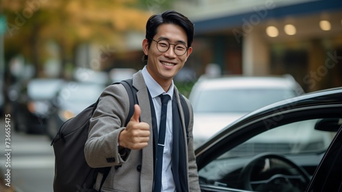 a man wearing glasses and a backpack giving a thumbs up © ion