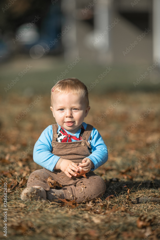 little baby boy 7 months old sitting on the green grass, walking in the fresh air. little baby boy 7 months old sitting on the green grass, walking in the fresh air.