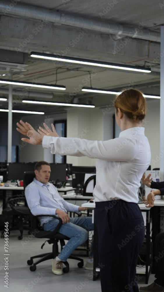 Office workers warm up during a break. Employees do fitness exercises at the workplace. Slow motion. Vertical video. Office workers warm up during a break. Employees do fitness exercises at the workplace. Slow motion. Vertical video.