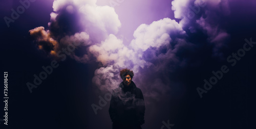 Cinematic appearance of a man among colored clouds. Mysterious person among smoke bombs