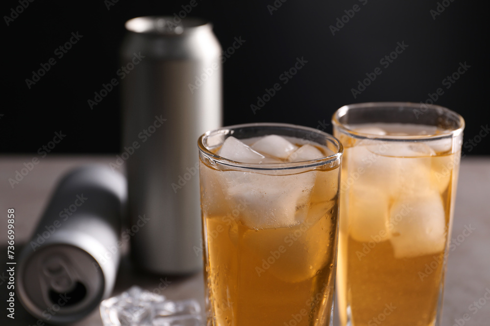 Energy drink with ice cubes in glasses and aluminium cans on table, closeup Energy drink with ice cubes in glasses and aluminium cans on table, closeup