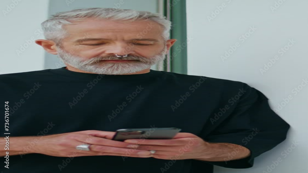 Bearded adult texting mobile phone on street vertical. Focused senior using Bearded adult texting mobile phone on street vertical. Focused senior using