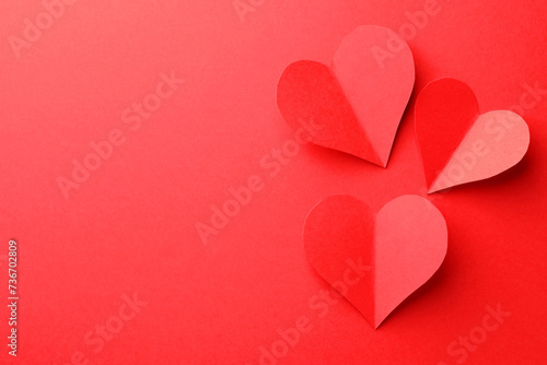Paper hearts on red background, flat lay. Space for text