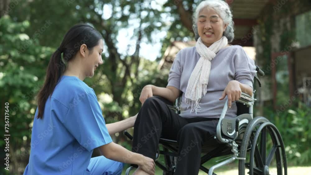 Squeeze and massage, Compassionate Asian woman provides care to elderly person in wheelchair outdoors. Engaging in physical therapy, happiness, mature individuals with grey hair. Squeeze and massage, Compassionate Asian woman provides care to elderly person in wheelchair outdoors. Engaging in physical therapy, happiness, mature individuals with grey hair.