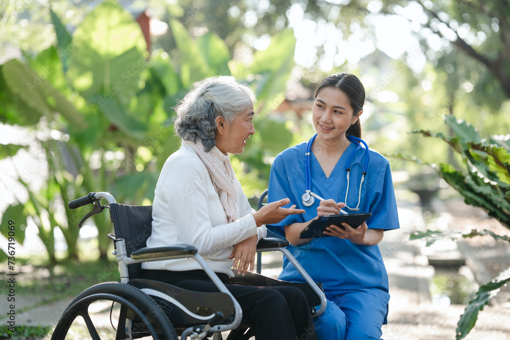 Compassionate Asian woman provides care to elderly person in wheelchair outdoors. Engaging in physical therapy, happiness, encouraging positive environment for mature individuals with grey hair. Compassionate Asian woman provides care to elderly person in wheelchair outdoors. Engaging in physical therapy, happiness, encouraging positive environment for mature individuals with grey hair.