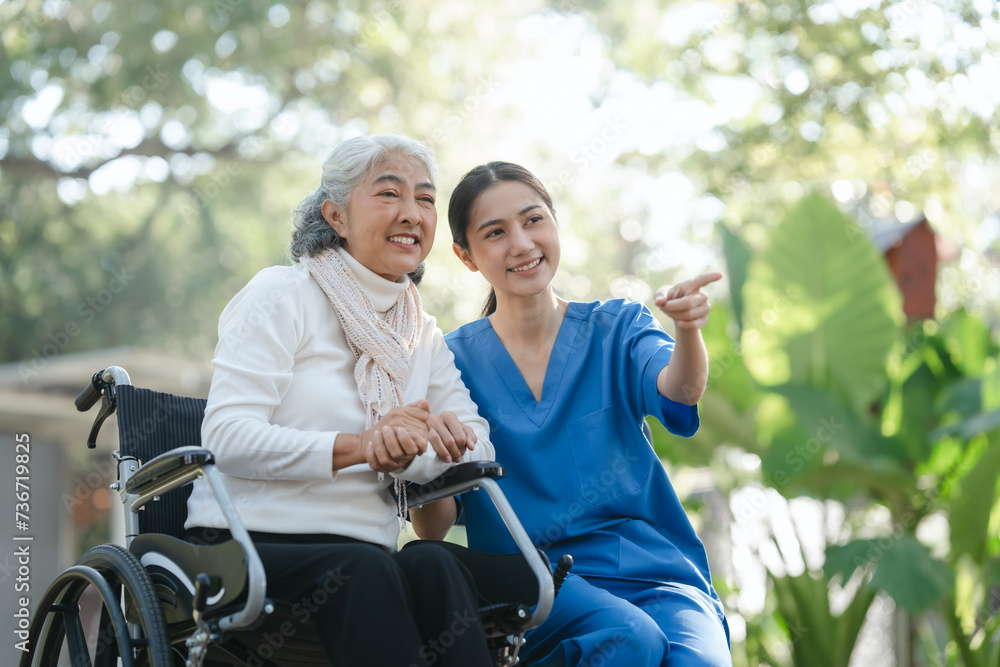 Compassionate Asian woman provides care to elderly person in wheelchair outdoors. Engaging in physical therapy, happiness, encouraging positive environment for mature individuals with grey hair. Compassionate Asian woman provides care to elderly person in wheelchair outdoors. Engaging in physical therapy, happiness, encouraging positive environment for mature individuals with grey hair.