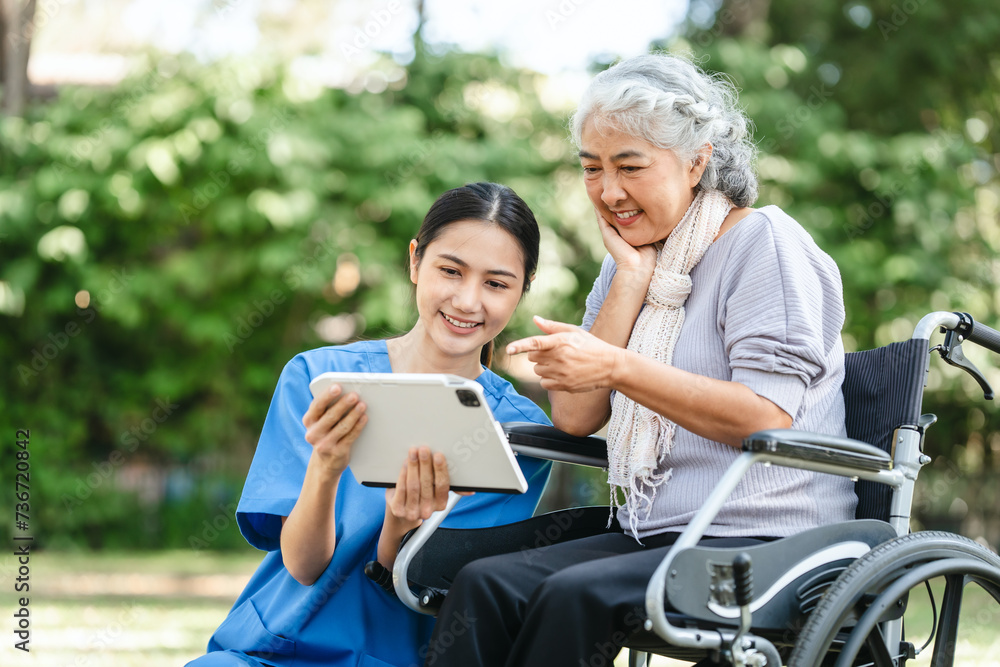 Compassionate Asian woman provides care to  elderly person in wheelchair outdoors. Engaging in physical therapy, happiness, encouraging positive environment for mature individuals with grey hair.
