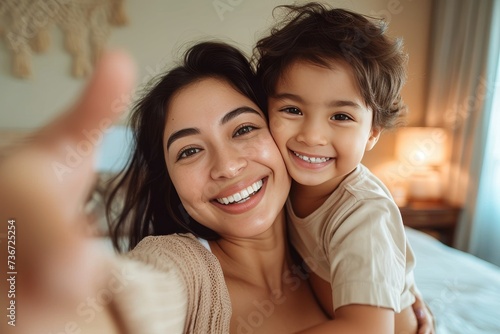 Smiling mother and son having fun as they take a playful and affectionate selfie at home photo