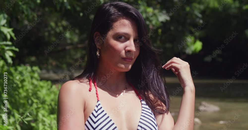 Facial close up of a young girl, dressed in a bikini, takes pleasure in a Caribbean island's tropical river Facial close up of a young girl, dressed in a bikini, takes pleasure in a Caribbean island's tropical river