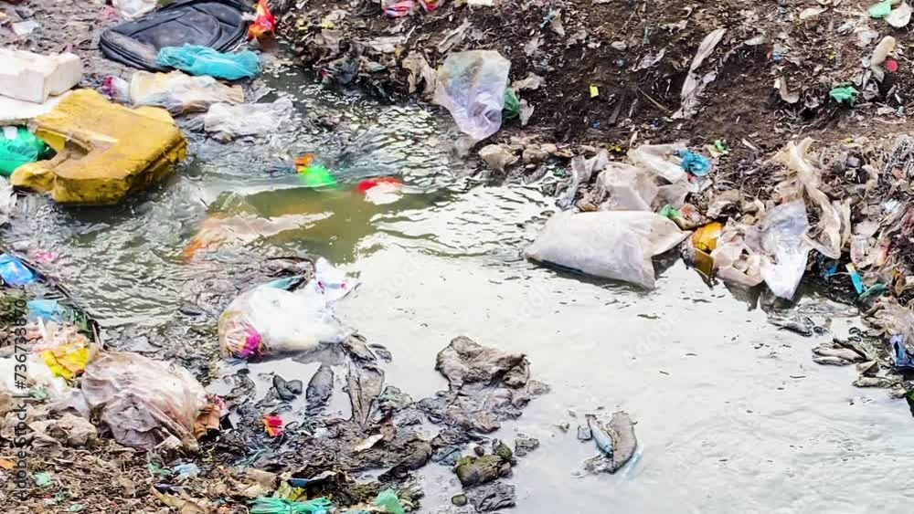Stream Flowing among Heaps of Plastic Waste and Pollution
