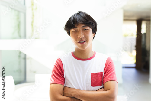 Teenage Asian boy stands confidently at home photo