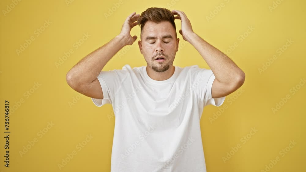 A surprised young man with a beard in a white shirt against a yellow background expressing shock. A surprised young man with a beard in a white shirt against a yellow background expressing shock.