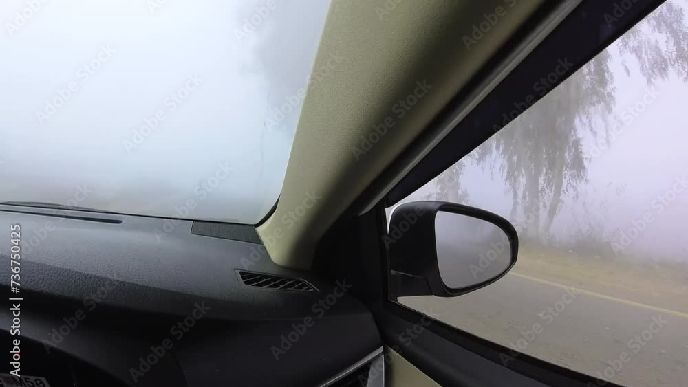 A car moving on the road in a cold and foggy weather with low visibility. A car moving on the road in a cold and foggy weather with low visibility.