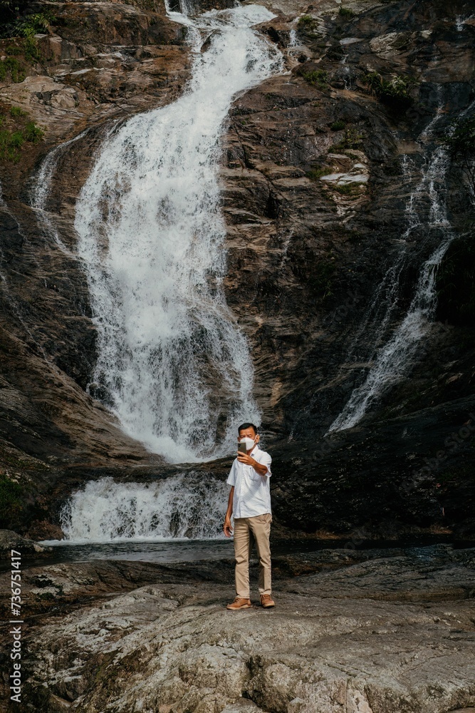 Tourists taking selfies with the Lata Kinjang waterfall near Cameron Highlands.