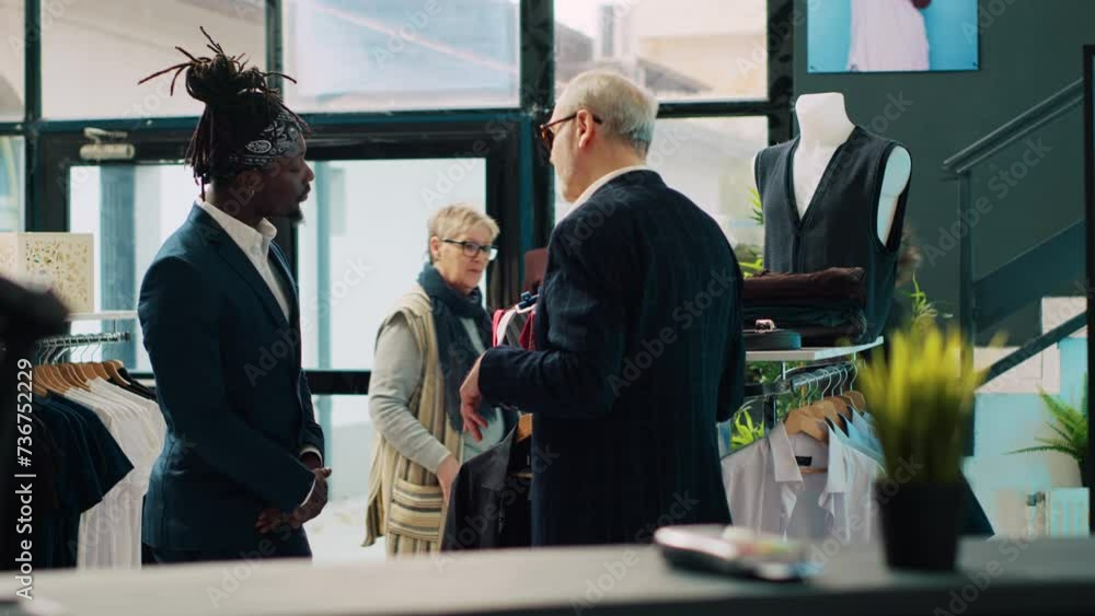 Vidéo Stock Senior designer teaching his apprentice to match ties on ...