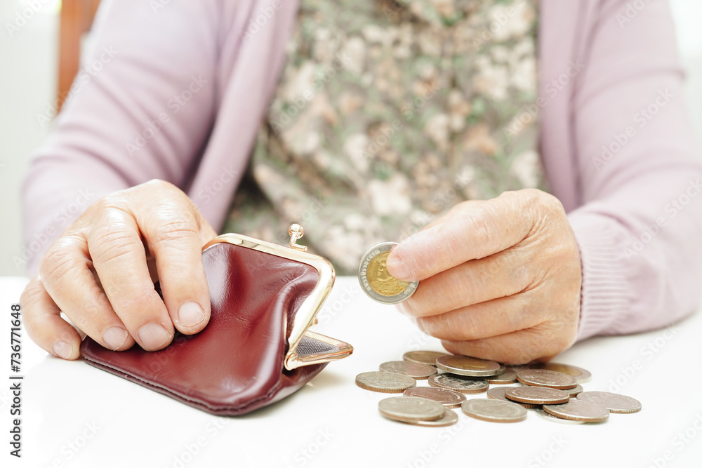 Obraz premium Retired elderly woman counting coins money and worry about monthly expenses and treatment fee payment.