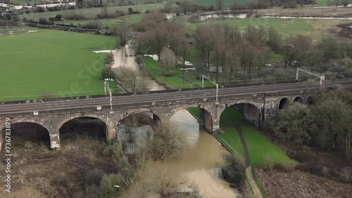 Aerial view of Haversham and Little Linford viaduct on an overcast day showing local flooding from River Great Ouse, Milton Keynes, England. Flying left to right around the viaduct with zoom out. photo