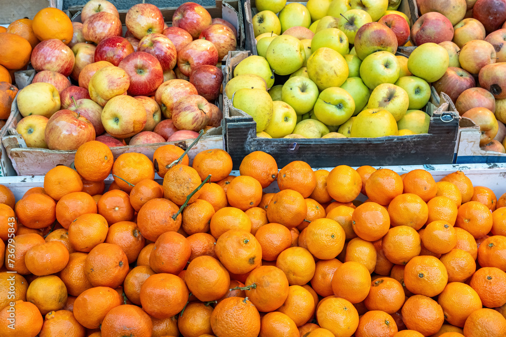 Tangerines and apples for sale at a market
