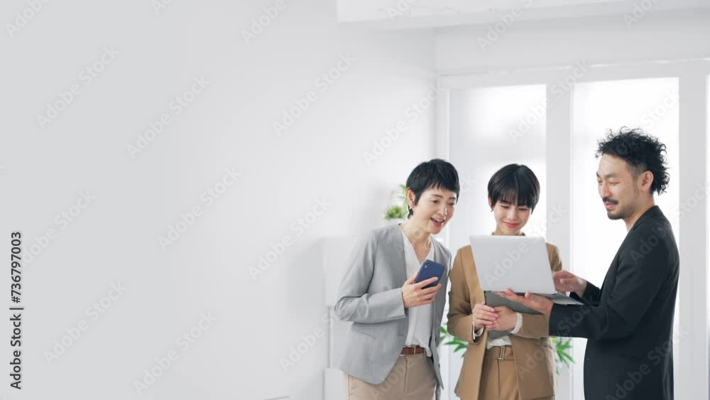 パソコンを見ながら話すビジネスパーソンのグループ パソコンを見ながら話すビジネスパーソンのグループ