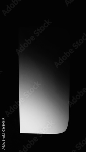 Black square vertical background in the middle. There is a gray gradient in the center of the image.