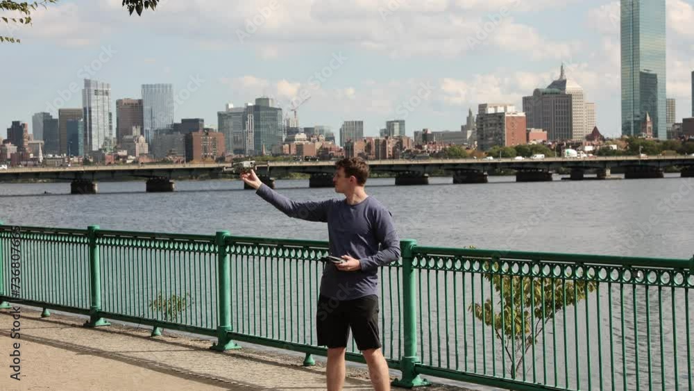 Professional drone pilot catch aircraft in hand after flight, Boston city Professional drone pilot catch aircraft in hand after flight, Boston city