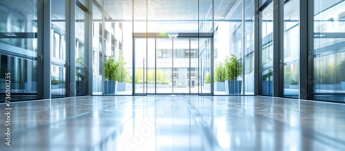 an empty lobby of an office building with a lot of windows and a sliding glass door . High quality photo