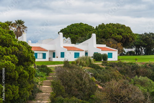 Charming white cottages nestled amidst lush green lawns  capturing the essence of a tranquil vacation spot.