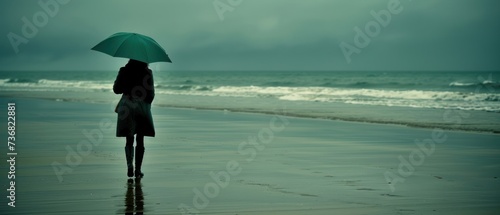 a person standing on a beach with an umbrella over their head and a body of water in front of them.
