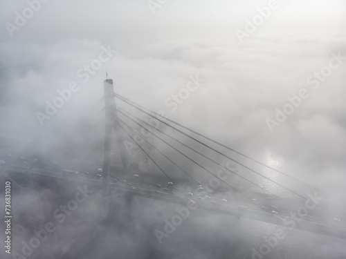 Bridge over the river at sunrise in the fog
