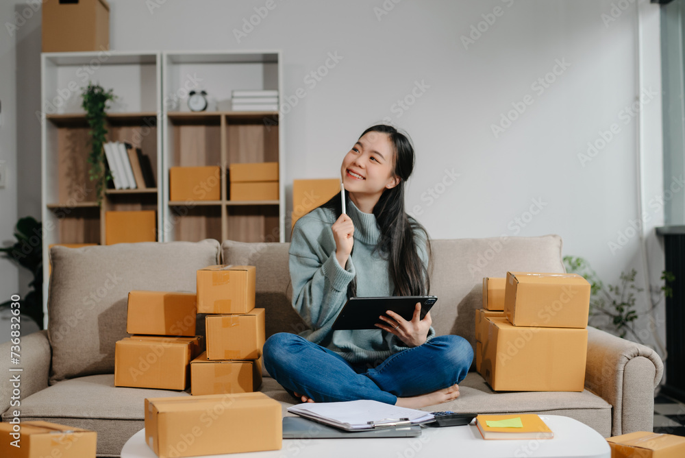 woman using smartphone or tablet taking receive and checking online purchase shopping order to preparing pack product box. . woman using smartphone or tablet taking receive and checking online purchase shopping order to preparing pack product box. .