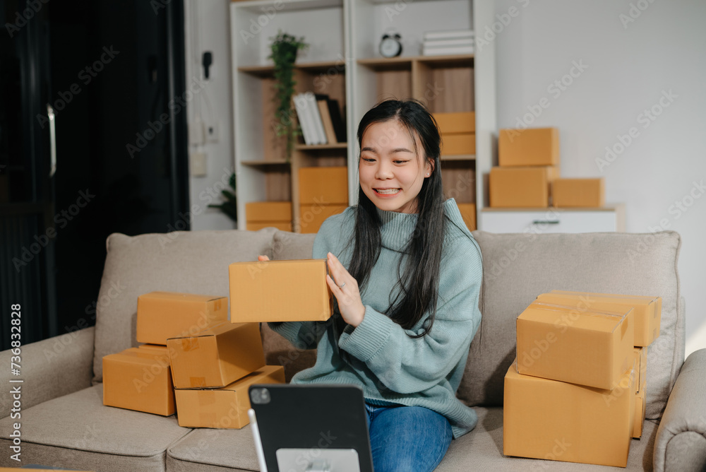 Asian lady blogger showing clothes in front of the camera to recording vlog video live streaming at her shop. Online Shopping Cart notion. Asian lady blogger showing clothes in front of the camera to recording vlog video live streaming at her shop. Online Shopping Cart notion.