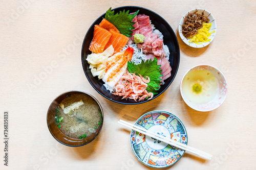 Japanese Food,Premium fresh raw seafood mixed rice bowl Japanese tasty food), Japanese Rice with sashimi of tuna, Maguro, Otoro, salmon, squid and ikura (Salmon eggs) on wood. photo