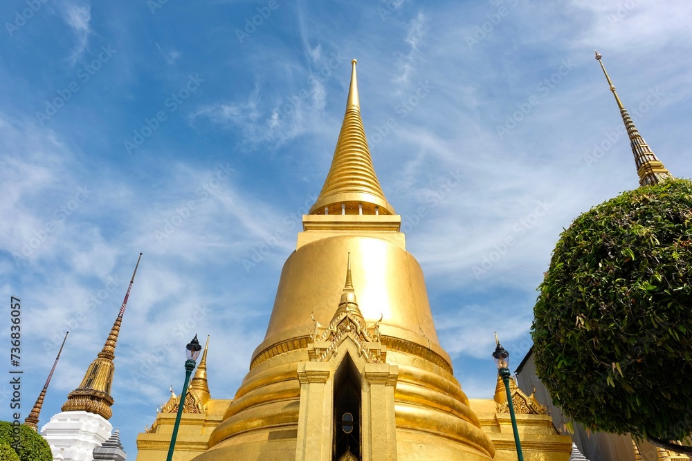Naklejka premium Phra Si Rattana Chedi: a gold bell-shaped stupa at the Wat Phra Kaew (Temple of the Emerald Buddha), housing relics of the Buddha from Sri Lanka, and covered in gold mosaic tiles - Bangkok, Thailand