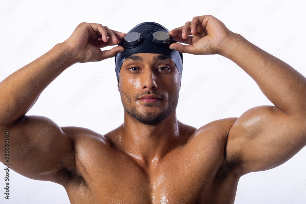 A young biracial male swimmer adjusts his swimming goggles A young biracial male swimmer adjusts his swimming goggles