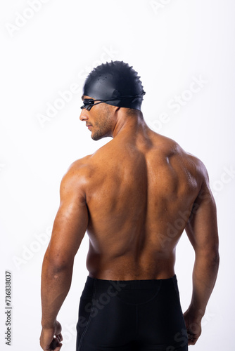 Athletic biracial male swimmer poses confidently